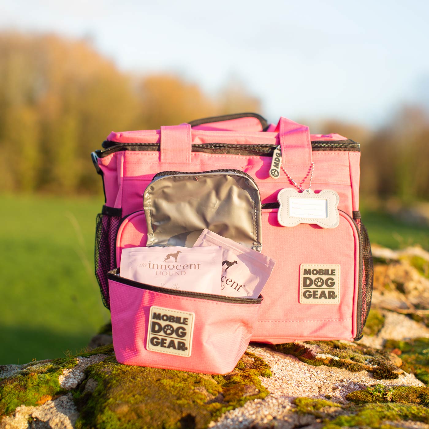 Discover, Mobile Dog Gear Week Away Bag, in Pink. The Perfect Away Bag for any Pet Parent, Featuring dividers to stack food and built in waste bag dispenser. Also Included feeding set, collapsible silicone bowls and placemat! The Perfect Gift For travel, meets airline requirements. Available Now at Lords & Labradors